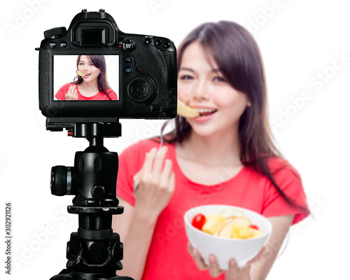 Asian food vlogger with fruit salad behind camera