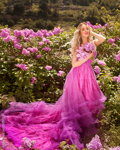 beautiful girl in a purple dress in a lilac garden