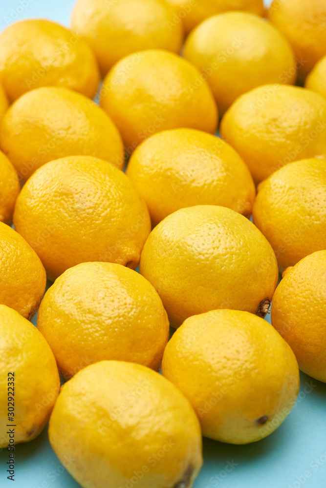 close up view of ripe yellow lemons on blue background close up view of ripe yellow lemons on blue background