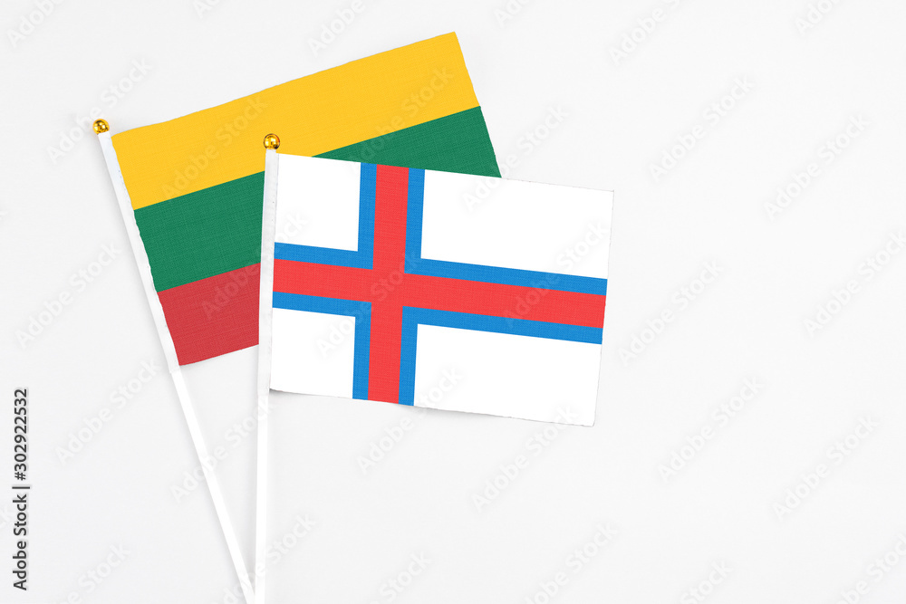 Faroe Islands and Lithuania stick flags on white background. High quality fabric, miniature national flag. Peaceful global concept.White floor for copy space.