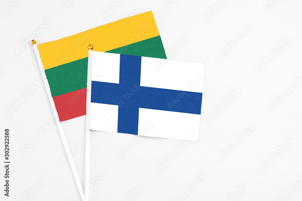 Finland and Lithuania stick flags on white background. High quality fabric, miniature national flag. Peaceful global concept.White floor for copy space.