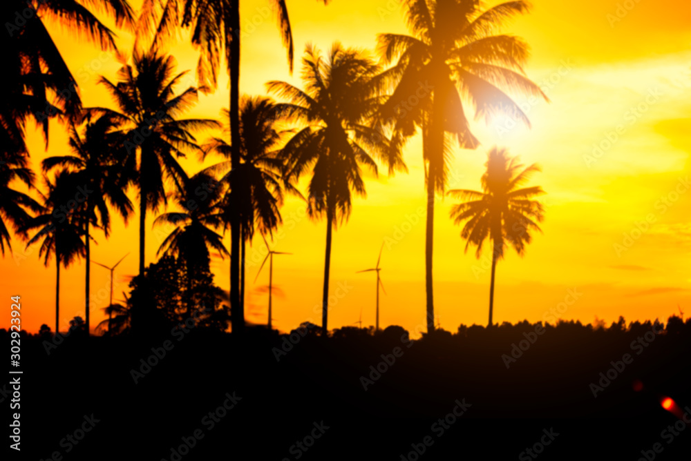 Blurred of silhouette coconut trees with sunset background