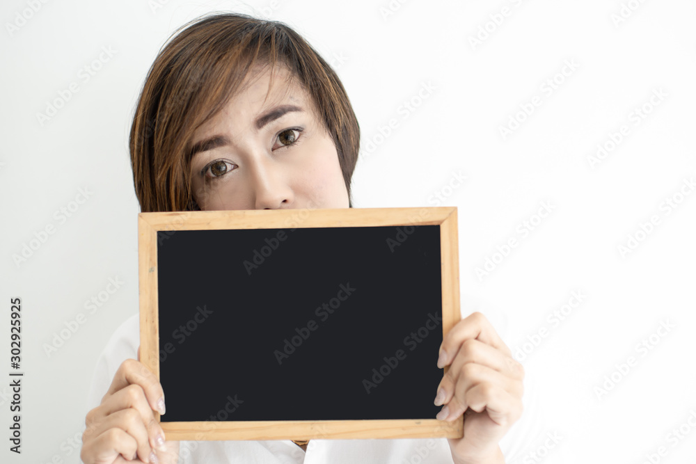 Beautiful woman holding blank blackboard with white wall. Beautiful woman holding blank blackboard with white wall.