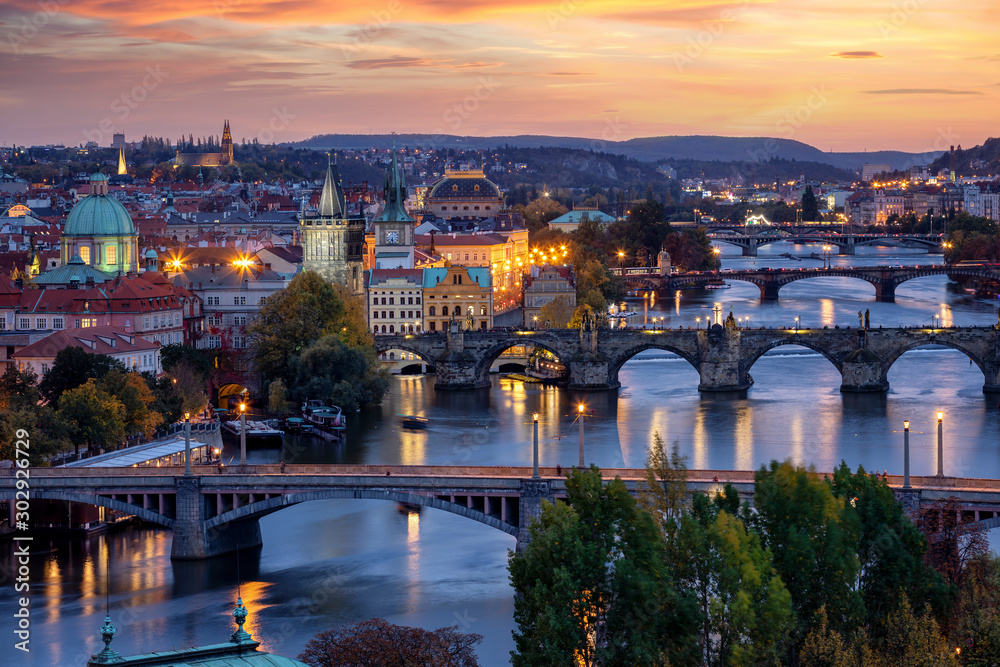 Blick über die Brücken von Prag auf die beleuchtete Altstadt und Moldau Fluss bei Sonnenuntergang im Herbst, Tschechien
