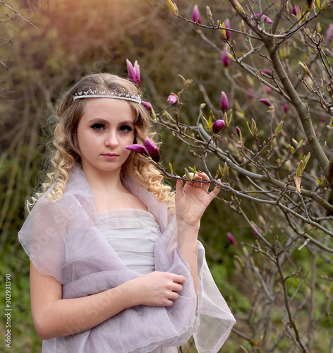 girl and magnolia in spring garden photo