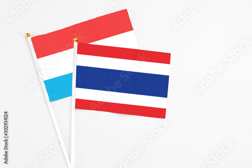 Thailand and Luxembourg stick flags on white background. High quality fabric  miniature national flag. Peaceful global concept.White floor for copy space.