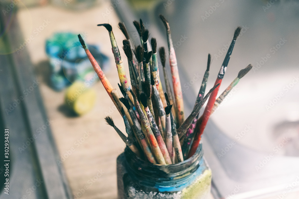 Creative workshop of the artist. Paint brushes in a jar. Many brushes for painting in one place Creative workshop of the artist. Paint brushes in a jar. Many brushes for painting in one place