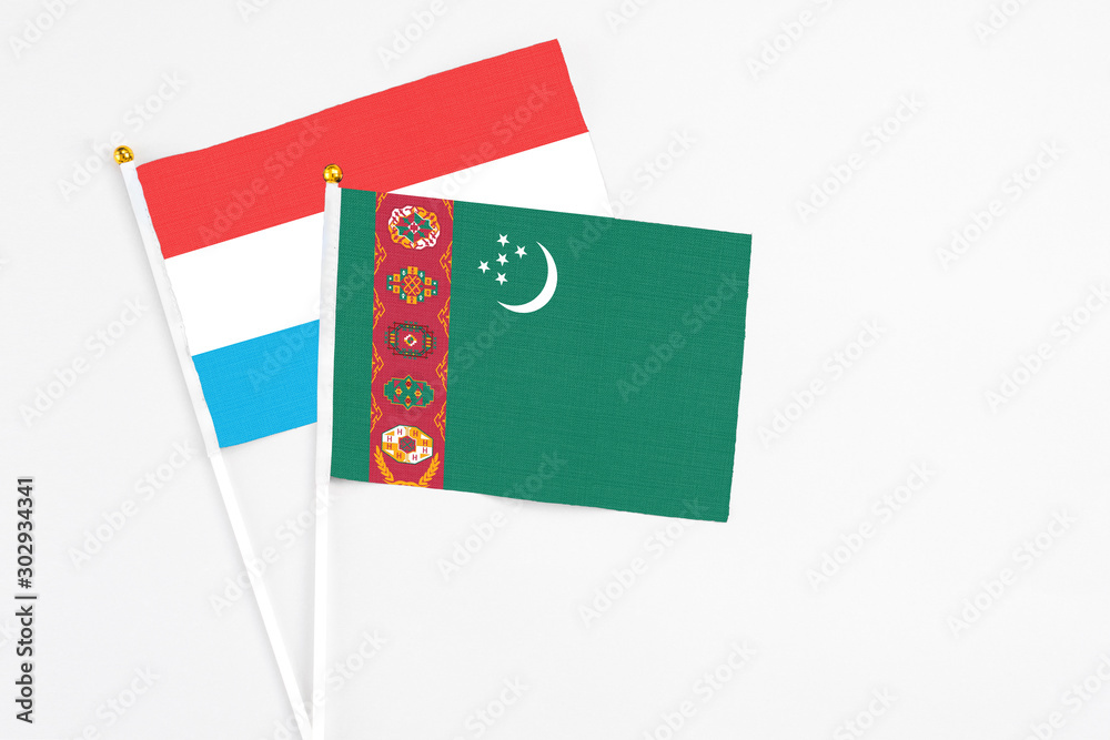 Turkmenistan and Luxembourg stick flags on white background. High quality fabric, miniature national flag. Peaceful global concept.White floor for copy space. Turkmenistan and Luxembourg stick flags on white background. High quality fabric, miniature national flag. Peaceful global concept.White floor for copy space.