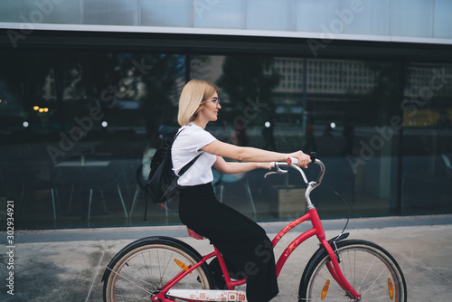 Attractive woman riding bike on street