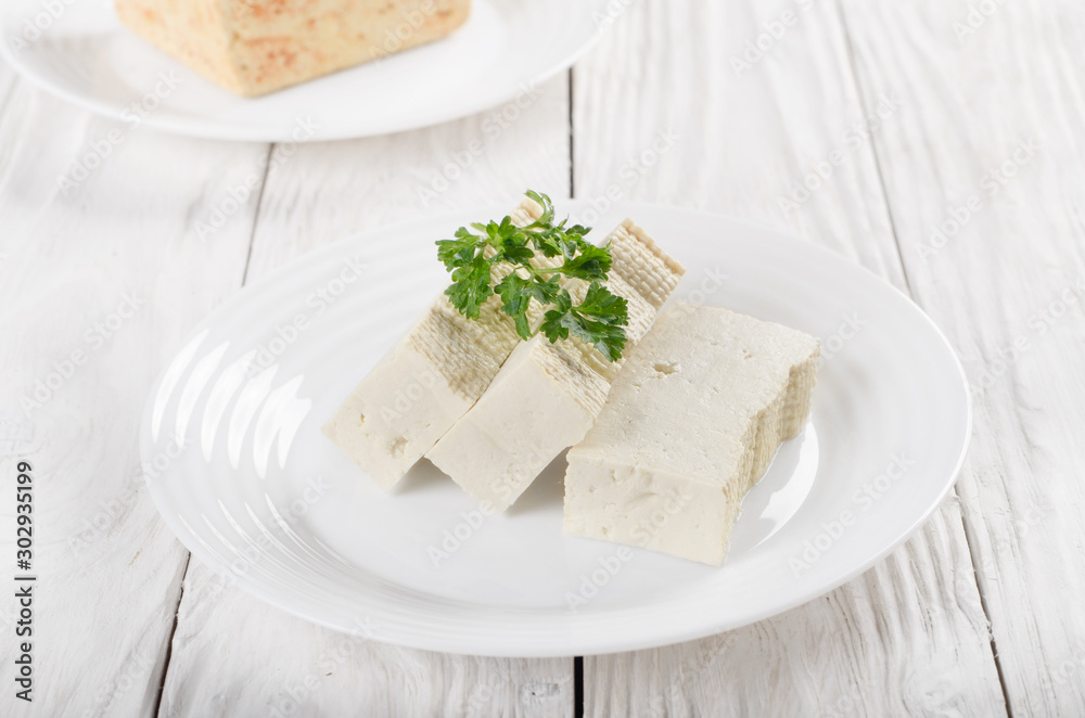 Soy Bean curd tofu on clay dish closeup. Non-dairy alternative substitute for cheese