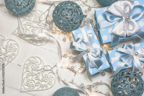 Blue gift boxes and ornaments on white wooden background