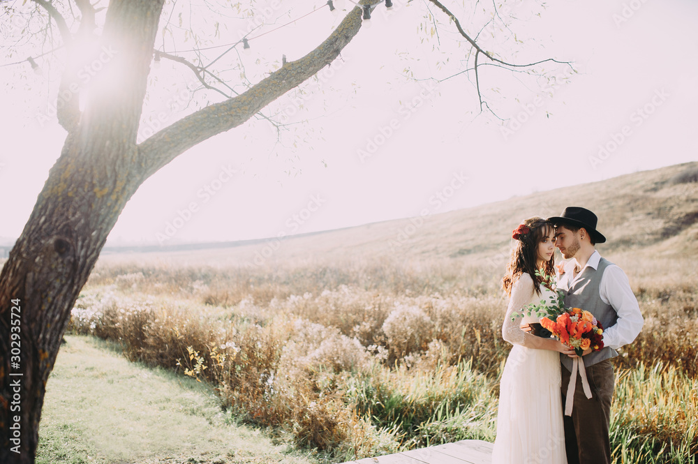 Happy beautiful wedding couple bride and groom at wedding day outdoors . Happy marriage couple outdoors on nature, soft sunny lights Happy beautiful wedding couple bride and groom at wedding day outdoors . Happy marriage couple outdoors on nature, soft sunny lights