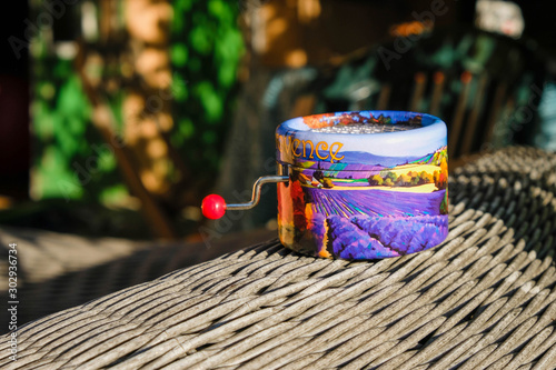 Valokuva Cute music box with Provence landscape  on wicker surface in bright sun