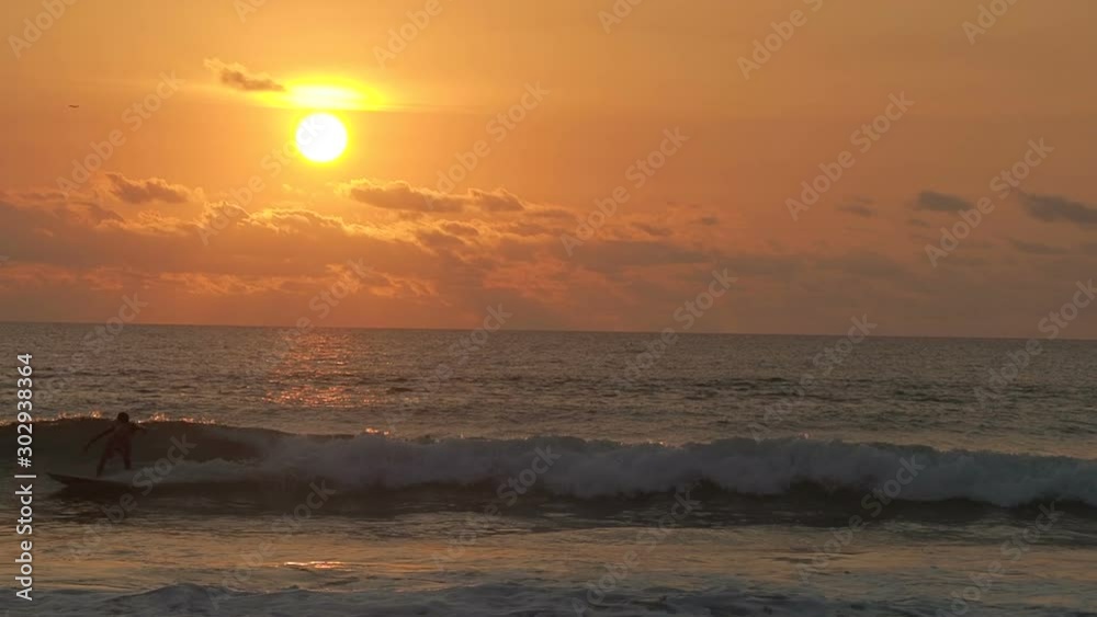 Surfing at Sunset, Cuta, Bali, Indonesia Surfing at Sunset, Cuta, Bali, Indonesia