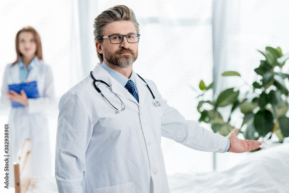 selective focus of doctor in white coat pointing with hand in hospital selective focus of doctor in white coat pointing with hand in hospital