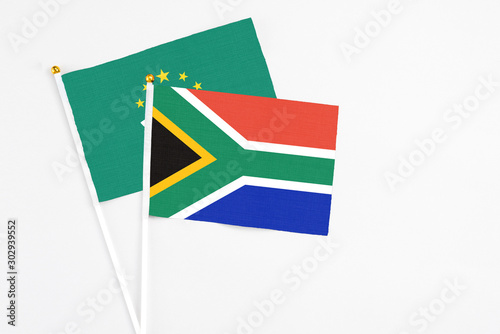 South Africa and Macao stick flags on white background. High quality fabric  miniature national flag. Peaceful global concept.White floor for copy space.