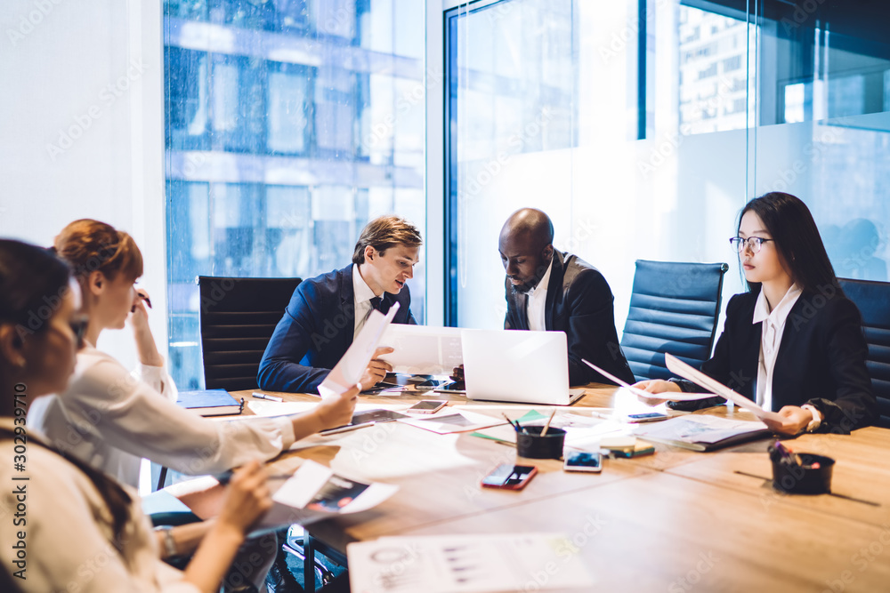 Multiracial business people with documents at table Multiracial business people with documents at table