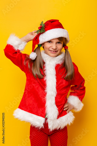 Child wearing Santa costume holding a mistletoe