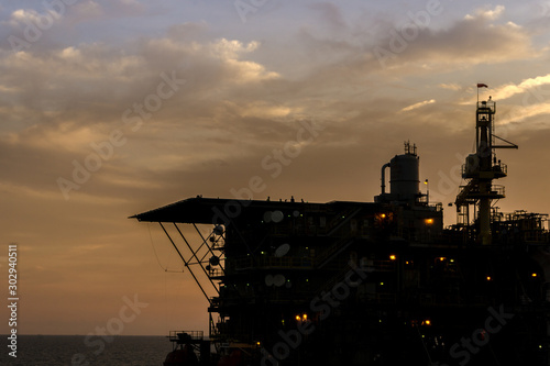Silhouette of oil production platform at oil field