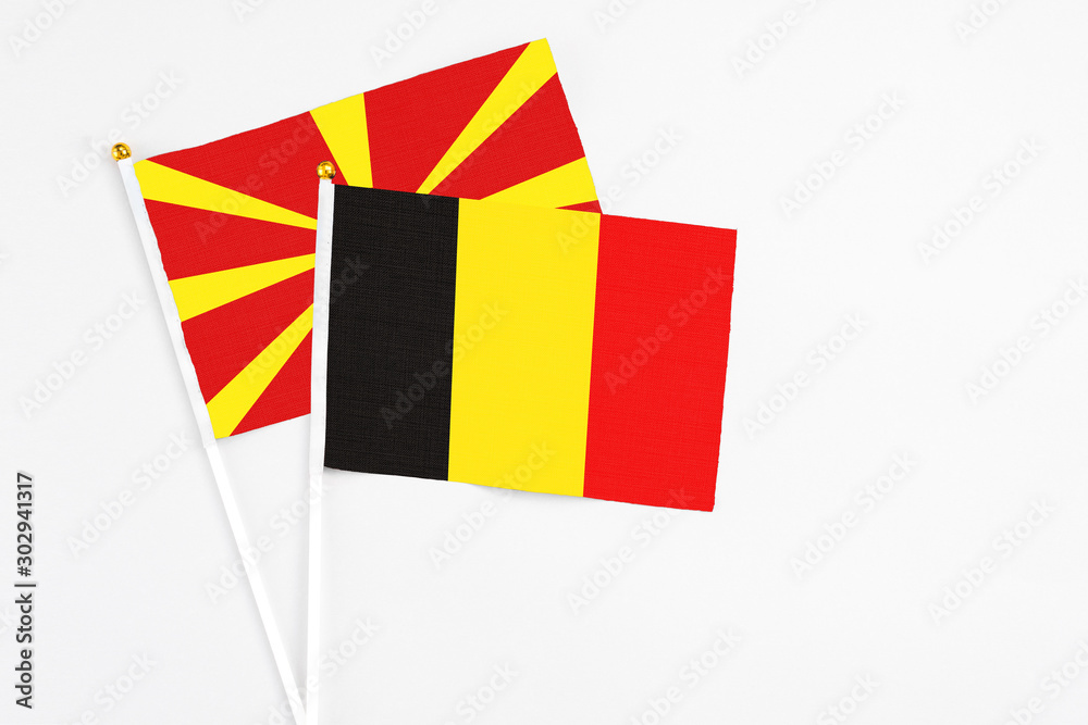 Belgium and Macedonia stick flags on white background. High quality fabric, miniature national flag. Peaceful global concept.White floor for copy space.