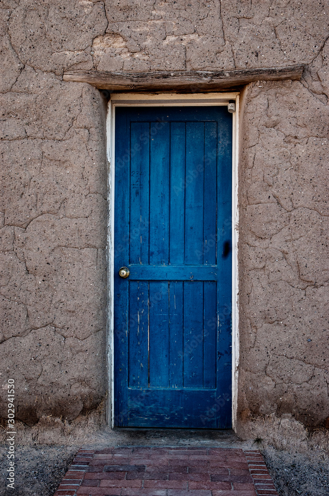 Old blue door traditional adobe building in New Mexico USA. 