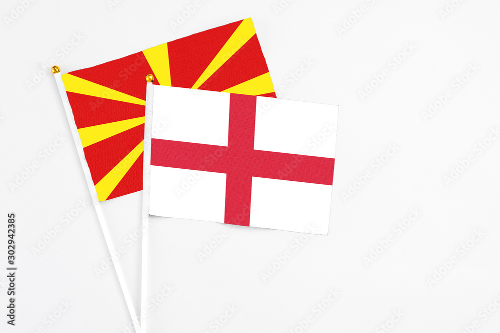 England and Macedonia stick flags on white background. High quality fabric, miniature national flag. Peaceful global concept.White floor for copy space.