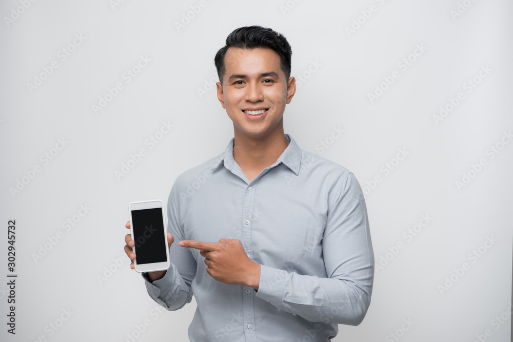 © makistock - Pleased happy young asian man holding smartphone pointing at cellphone screen as showing awesome new phone © makistock - Pleased happy young asian man holding smartphone pointing at cellphone screen as showing awesome new phone