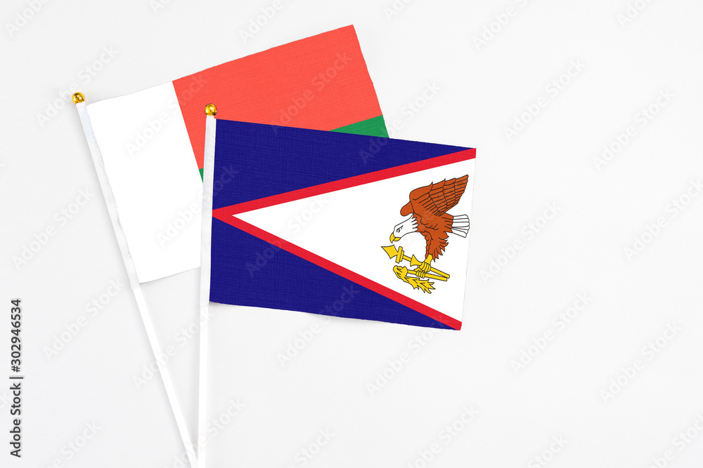 American Samoa and Madagascar stick flags on white background. High quality fabric, miniature national flag. Peaceful global concept.White floor for copy space. American Samoa and Madagascar stick flags on white background. High quality fabric, miniature national flag. Peaceful global concept.White floor for copy space.