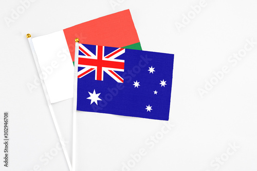 Australia and Madagascar stick flags on white background. High quality fabric, miniature national flag. Peaceful global concept.White floor for copy space. photo