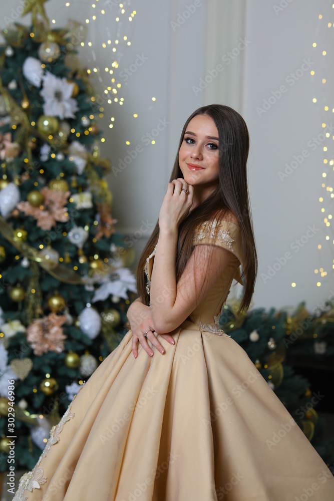 Happy New Year to you. Girl is happy about the New Year. New year's feeling. Merry christmas. Beautiful girl with long hair and perfect makeup. Woman in trendy dress at christmas party. 