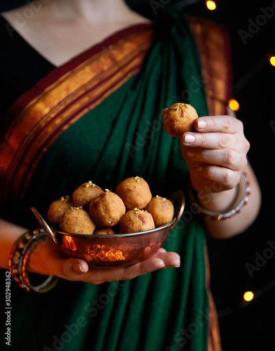 Woman with Besan Laddoo Indian sweets on Diwali night photo