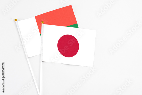 Free Download Japan and Madagascar stick flags on white background. High quality fabric, miniature national flag. Peaceful global concept.White floor for copy space. - GFXLoad
