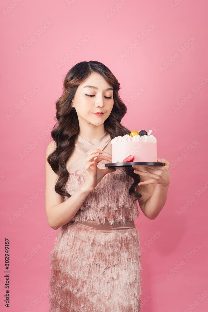 Joyful woman with cake front pink background Joyful woman with cake front pink background