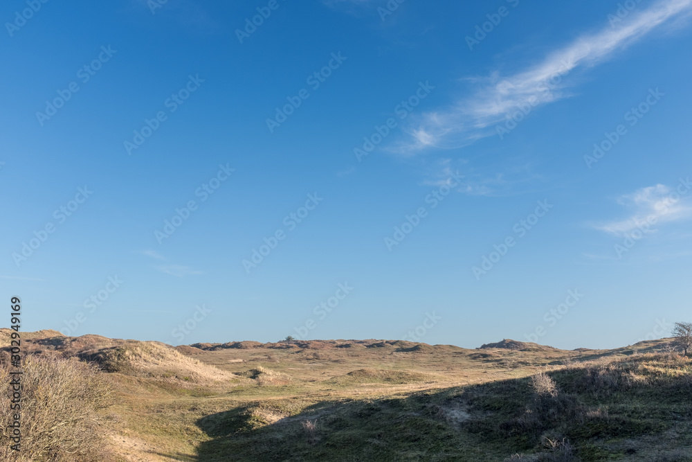 View over a grassy plateau with a blue sky