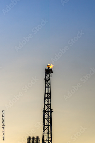 Silhouette of oil production platform during sunset