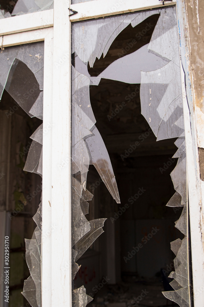 A window in an old house. Broken glass. Sharp pieces. Dirty concrete walls.