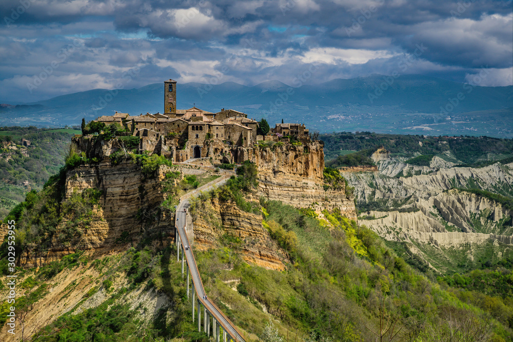 Civita Bagnoregio Perched on top of a hill among the valleys formed by Chiaro and Torbido streams, Civita appears clinged to the edge of a cliff where it dominates the wide desolated valley 