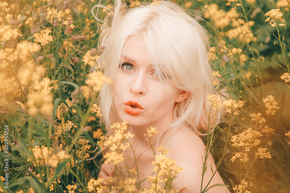 beautiful young blonde woman on the meadow with yellow flowers on a warm summer day beautiful young blonde woman on the meadow with yellow flowers on a warm summer day