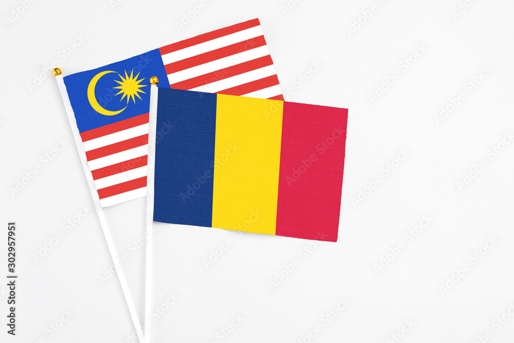 Chad and Malaysia stick flags on white background. High quality fabric, miniature national flag. Peaceful global concept.White floor for copy space. Chad and Malaysia stick flags on white background. High quality fabric, miniature national flag. Peaceful global concept.White floor for copy space.