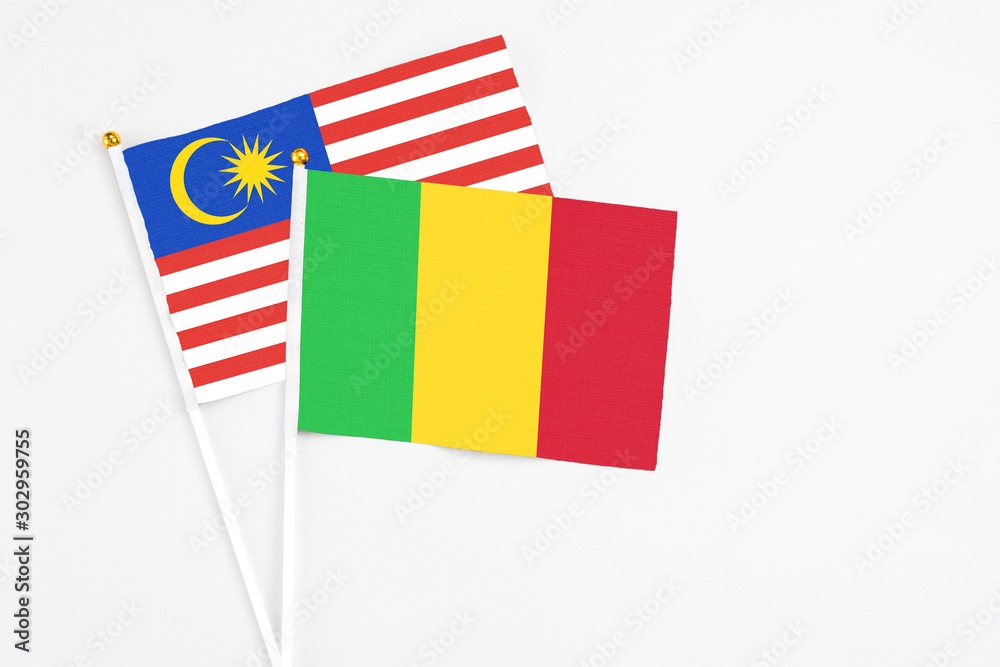 Mali and Malaysia stick flags on white background. High quality fabric, miniature national flag. Peaceful global concept.White floor for copy space. Mali and Malaysia stick flags on white background. High quality fabric, miniature national flag. Peaceful global concept.White floor for copy space.