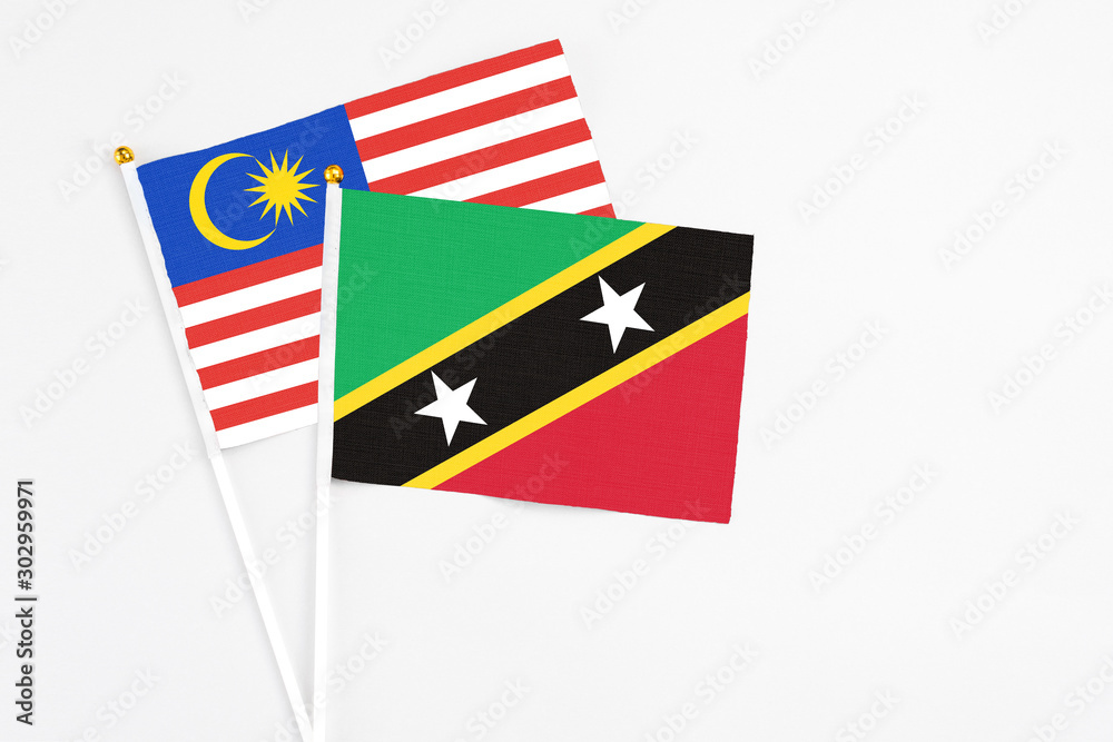 Saint Kitts And Nevis and Malaysia stick flags on white background. High quality fabric, miniature national flag. Peaceful global concept.White floor for copy space. Saint Kitts And Nevis and Malaysia stick flags on white background. High quality fabric, miniature national flag. Peaceful global concept.White floor for copy space.