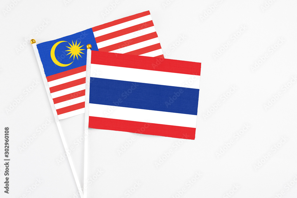 Thailand and Malaysia stick flags on white background. High quality fabric, miniature national flag. Peaceful global concept.White floor for copy space.