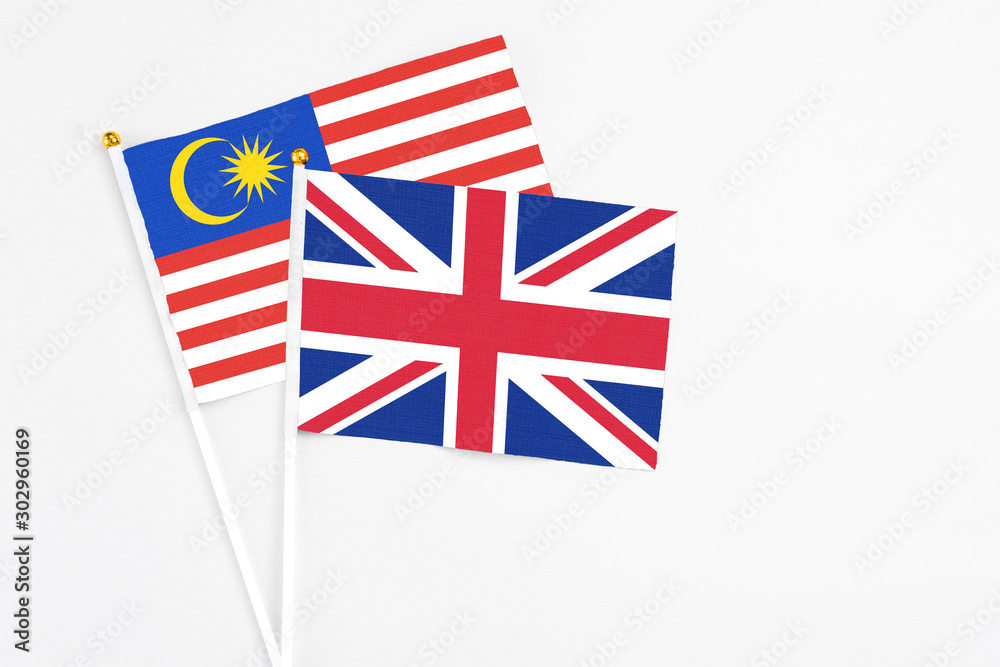 United Kingdom and Malaysia stick flags on white background. High quality fabric, miniature national flag. Peaceful global concept.White floor for copy space. United Kingdom and Malaysia stick flags on white background. High quality fabric, miniature national flag. Peaceful global concept.White floor for copy space.