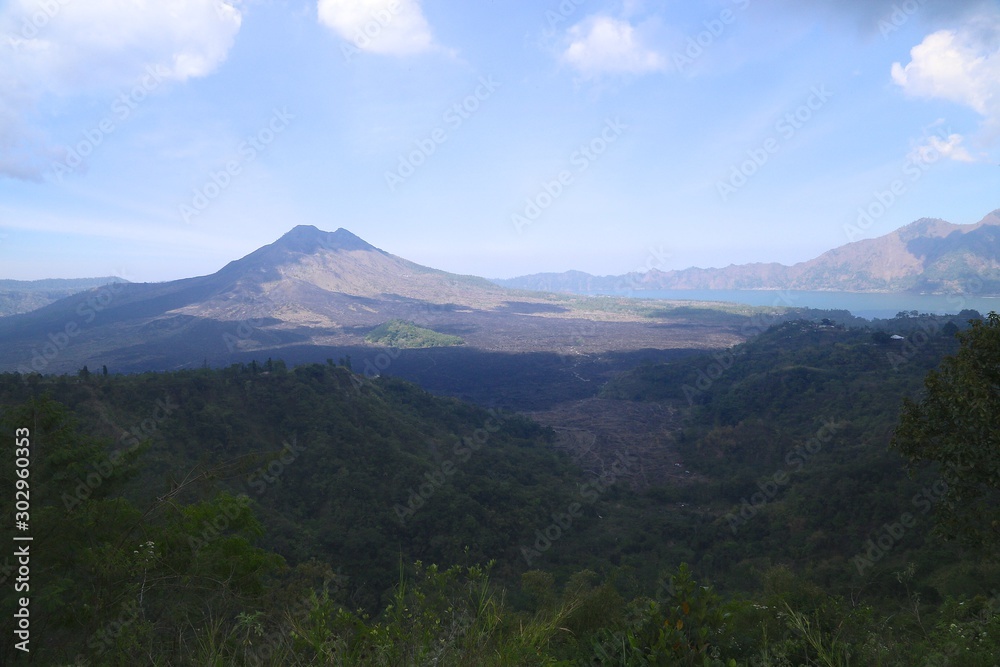 Volcanoes and forests of tropical evergreen island, sky and clouds