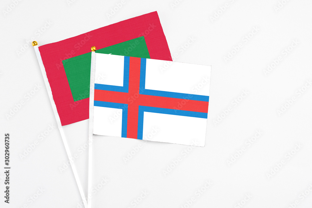 Faroe Islands and Maldives stick flags on white background. High quality fabric, miniature national flag. Peaceful global concept.White floor for copy space.