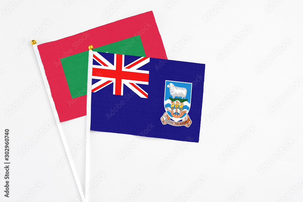 Fototapeta premium Falkland Islands and Maldives stick flags on white background. High quality fabric, miniature national flag. Peaceful global concept.White floor for copy space.
