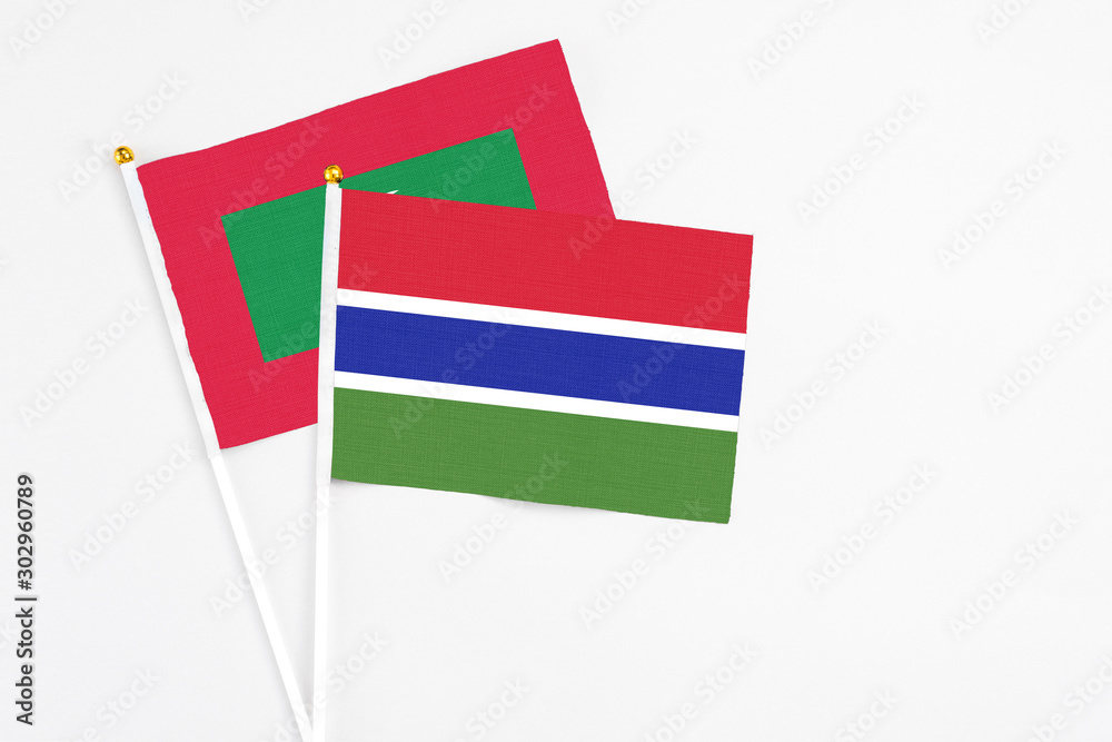 Obraz premium Gambia and Maldives stick flags on white background. High quality fabric, miniature national flag. Peaceful global concept.White floor for copy space.