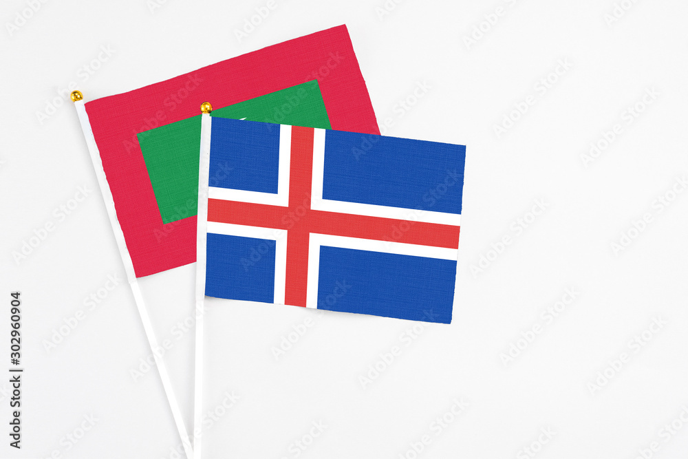 Iceland and Maldives stick flags on white background. High quality fabric, miniature national flag. Peaceful global concept.White floor for copy space.