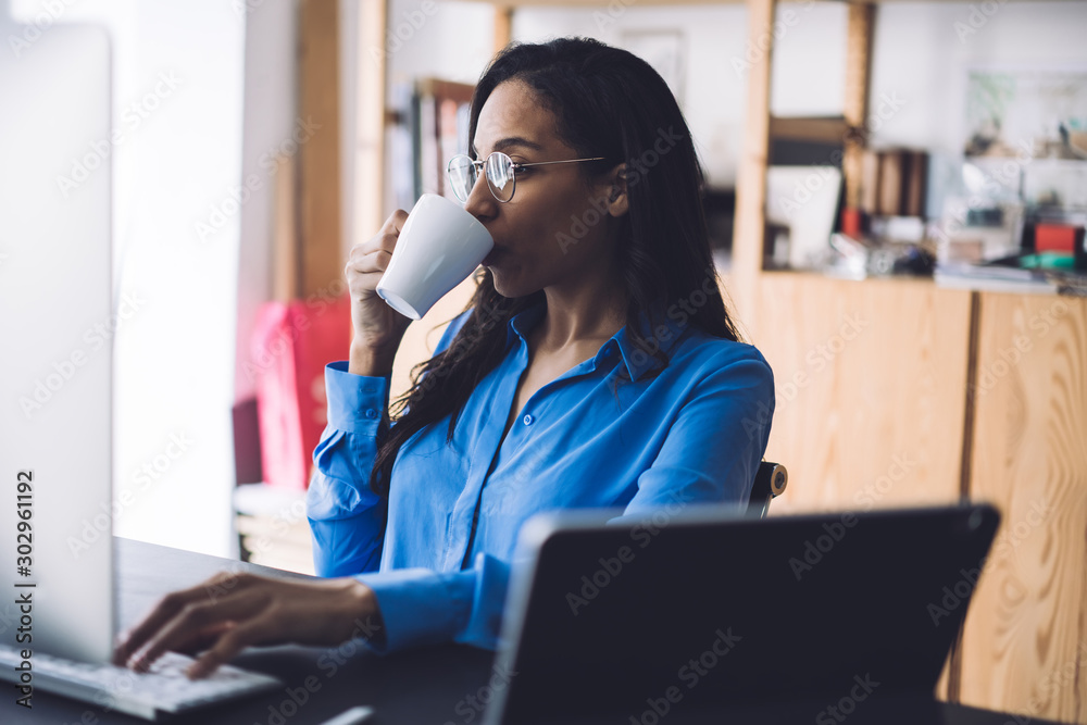 Smart black woman drinking coffee in office Smart black woman drinking coffee in office