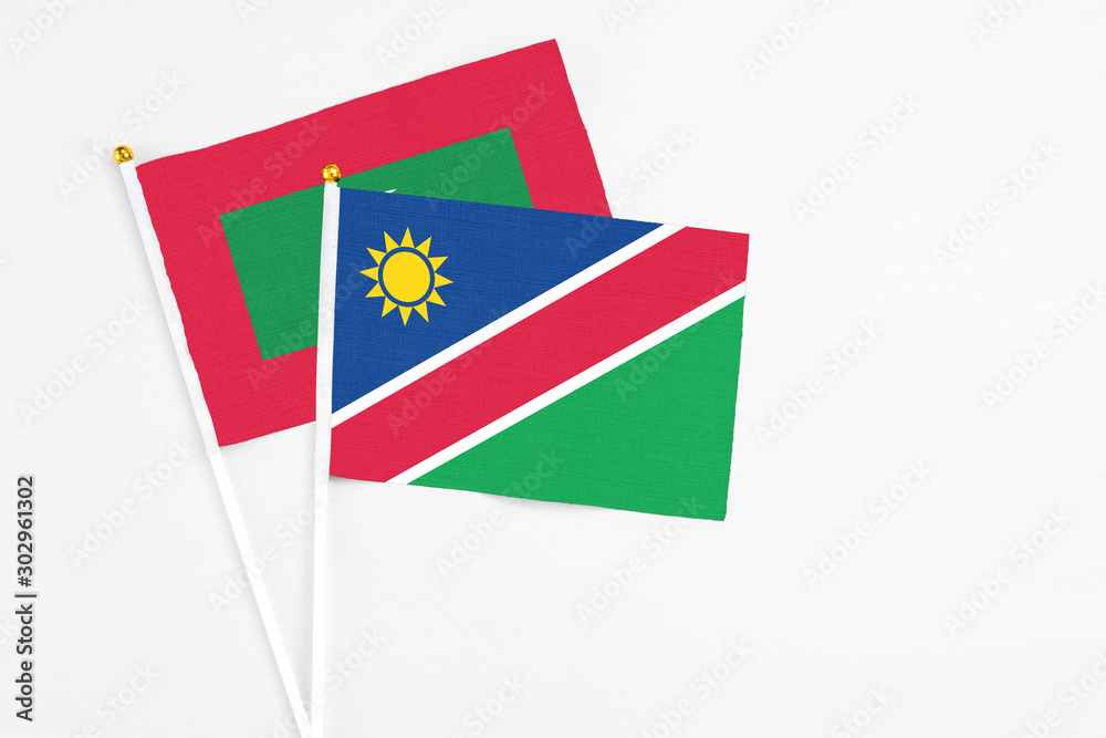 Namibia and Maldives stick flags on white background. High quality fabric, miniature national flag. Peaceful global concept.White floor for copy space. Namibia and Maldives stick flags on white background. High quality fabric, miniature national flag. Peaceful global concept.White floor for copy space.